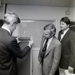 Men Applying a Telecredit Sticker for Master Charge, A by George Skip Gandy IV