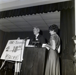 Man and Woman on Stage by 10th Anniversary Sign for Master Charge by George Skip Gandy IV