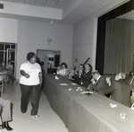 People at Panel Table Applauding Woman Walking Past for Master Charge by George Skip Gandy IV