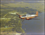 Twin Bonanza Plane Flies Over Coastline in Opa-locka, Florida, B