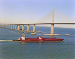 Tugboat Dixie Commander Pushing a Dredge Under the Sunshine Skyway Bridge, Tampa Bay, Florida, B by George Skip Gandy IV