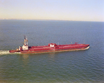 Tugboat Dixie Commander Pushing a Dredge on Open Waters, Tampa Bay, Florida, C by George Skip Gandy IV