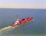 Tugboat Dixie Commander Pushing a Dredge Toward the Sunshine Skyway Bridge, Tampa Bay, Florida, A by George Skip Gandy IV