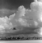 Biplane and Commercial Airplane in Flight Over Runway, Tampa, Florida, A by George Skip Gandy IV