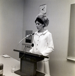 Woman Speaking at Podium During Exchange National Bank Fashion Show by George Skip Gandy IV