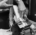 Person Inspecting the Parts of a Dennison Dial Set Printer, H by George Skip Gandy IV