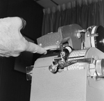 Person Inspecting the Parts of a Dennison Dial Set Printer, L by George Skip Gandy IV
