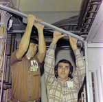 Two men Checking the Metal Framework Along with Electrical Wiring, A by George Skip Gandy IV