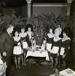 Waitresses and a Man Gather Around a Table with Bottles at Maison Rouge Restaurant, A by George Skip Gandy IV