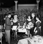 Waitresses and a Man Gather Around a Table with Bottles at Maison Rouge Restaurant, E by George Skip Gandy IV
