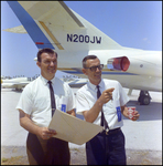 Two Men in Front of Plane Display by Skip Gandy