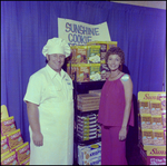 Man and Woman Smiling Next to a Display of Sunshine Cookie, Tampa, Florida