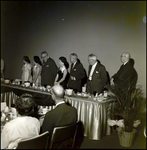 Group of Well Dress Standing by a Banquet Table, A by Skip Gandy