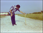 Man Holding Measuring Stick on Ground