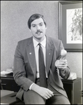 Man Holding Phone in an Office, F by Skip Gandy