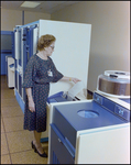 Woman Inspecting Teleprocessing System Mainframe, E by Skip Gandy