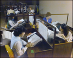 Women Looking at Directories in an Office, A by Skip Gandy