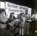 Group Celebrating In Front of British Airways Sign