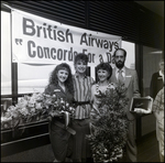 Group Posing in Front of British Airways Sign, A