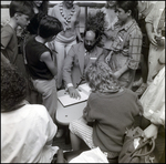 Man Signing Paper in a Crowd by Skip Gandy