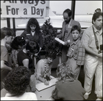 Woman Signing Paper in a Crowd by Skip Gandy