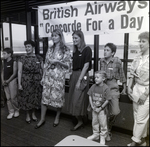 Group Posing in Front of British Airways Sign, B