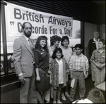 Group Posing in Front of British Airways Sign, C