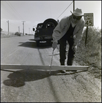 Man Measures Depression in Road, Tampa, Florida, A by George Skip Gandy IV