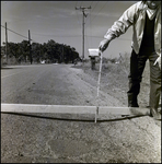 Man Measures Depression in Road, Tampa, Florida, C by George Skip Gandy IV