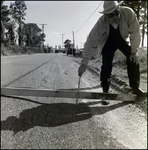 Man Measures Depression in Road, Tampa, Florida, E by George Skip Gandy IV