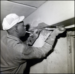 Worker Applies Concrete to Damaged Wall near a Doorframe, Tampa, Florida, A by George Skip Gandy IV