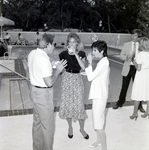 Man in Sunglasses in Conversation with Two Women by a Pool by George Skip Gandy IV