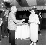 Woman in a Black Hat and a Man Talking at a Party by George Skip Gandy IV