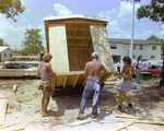 Workers Securing Bottom of Wooden Shed by George Skip Gandy IV