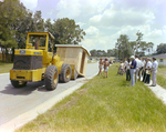 People Gathering Around a Bulldozer Holding a Shed by George Skip Gandy IV