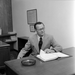 Man With Glasses Sitting at Desk at O.H. Carter, Co. Inc., A by George Skip Gandy IV