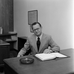 Man With Glasses Sitting at Desk at O.H. Carter, Co. Inc., C by George Skip Gandy IV