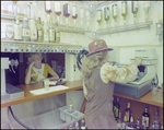 Woman Tending Bar and Operating Cash Register, G by Skip Gandy