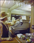 Woman Operating Cash Register, A by Skip Gandy