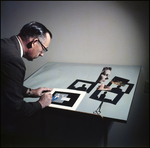 Man Clipping Photographs in Studio by Skip Gandy