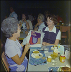 Women Discussing Clothes Over Food at an Event by George Skip Gandy IV