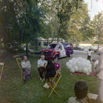 Attendees Socialize Near Parked Vehicles at a Cosmopolitan Realty and Investment Corp. Event, A by George Skip Gandy IV