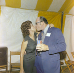 Jim Stone and Attendee Kiss for a Photo During a Cosmopolitan Realty and Investment Corp. Event by George Skip Gandy IV