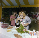 Connie Mercer Smells a Floral Centerpiece on a Refreshment Table During a Cosmopolitan Realty and Investment Corp. Event by George Skip Gandy IV