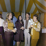 Four Attendees Pose for a Photo Inside a Tent During a Cosmopolitan Realty and Investment Corp. Event by George Skip Gandy IV