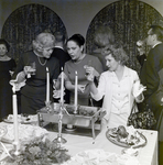 Three Attendees Socialize Near a Refreshment Area at a Maas Brothers Executives Reception for Imprevu by Coty by George Skip Gandy IV