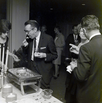 Attendee Samples an Hors d'oeuvre at a Maas Brothers Executives Reception for Imprevu by Coty by George Skip Gandy IV