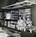 Nancy Adams and Maas Brothers Employee Stand Behind a Coty Service Counter by George Skip Gandy IV