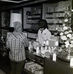 Maas Brothers Employee Assists Customer at a Coty Service Counter by George Skip Gandy IV