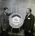 James Ward and Man Next to All Electric Award Sign, A by George Skip Gandy IV